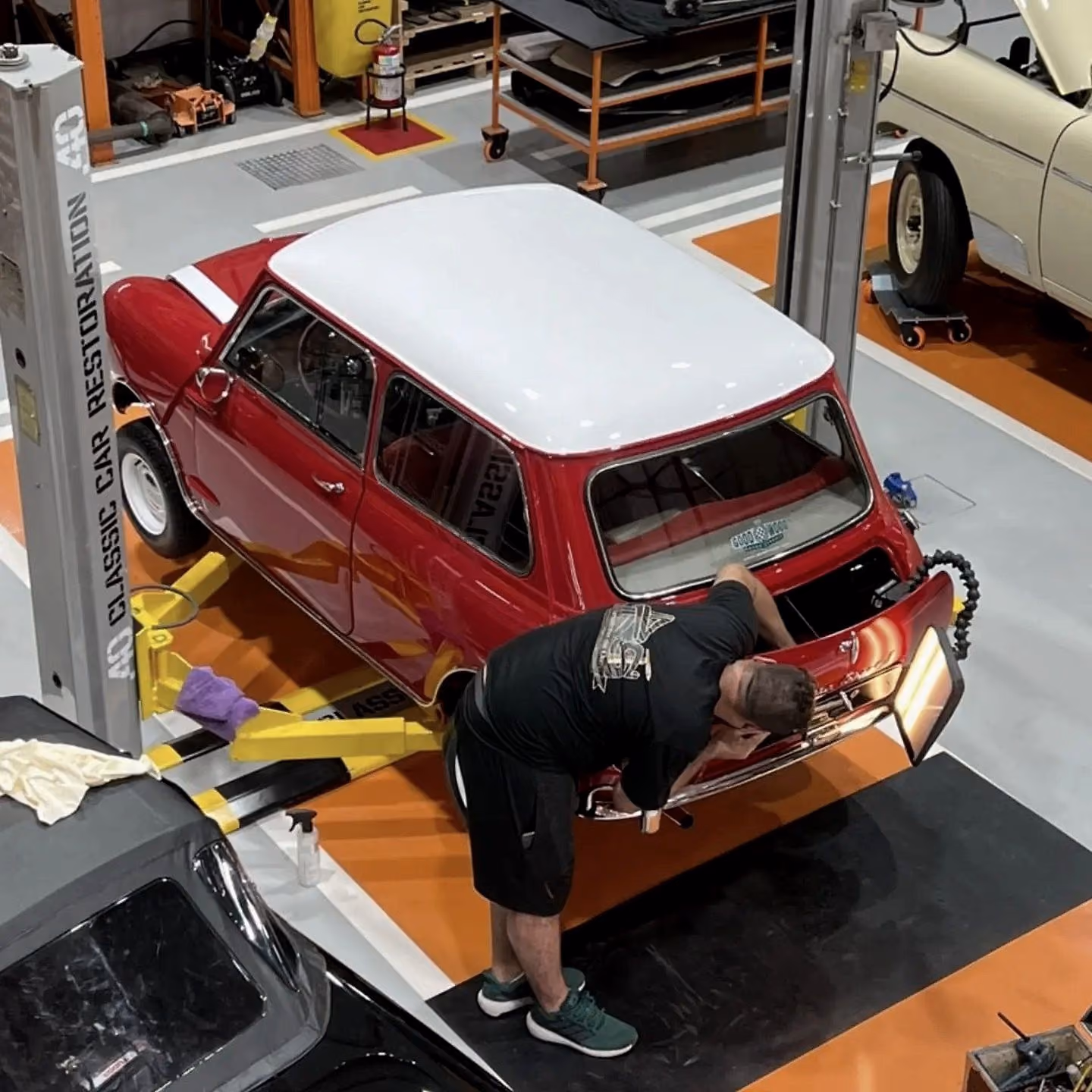 Mini clássico vermelho de teto branco em reparo na tampa traseira