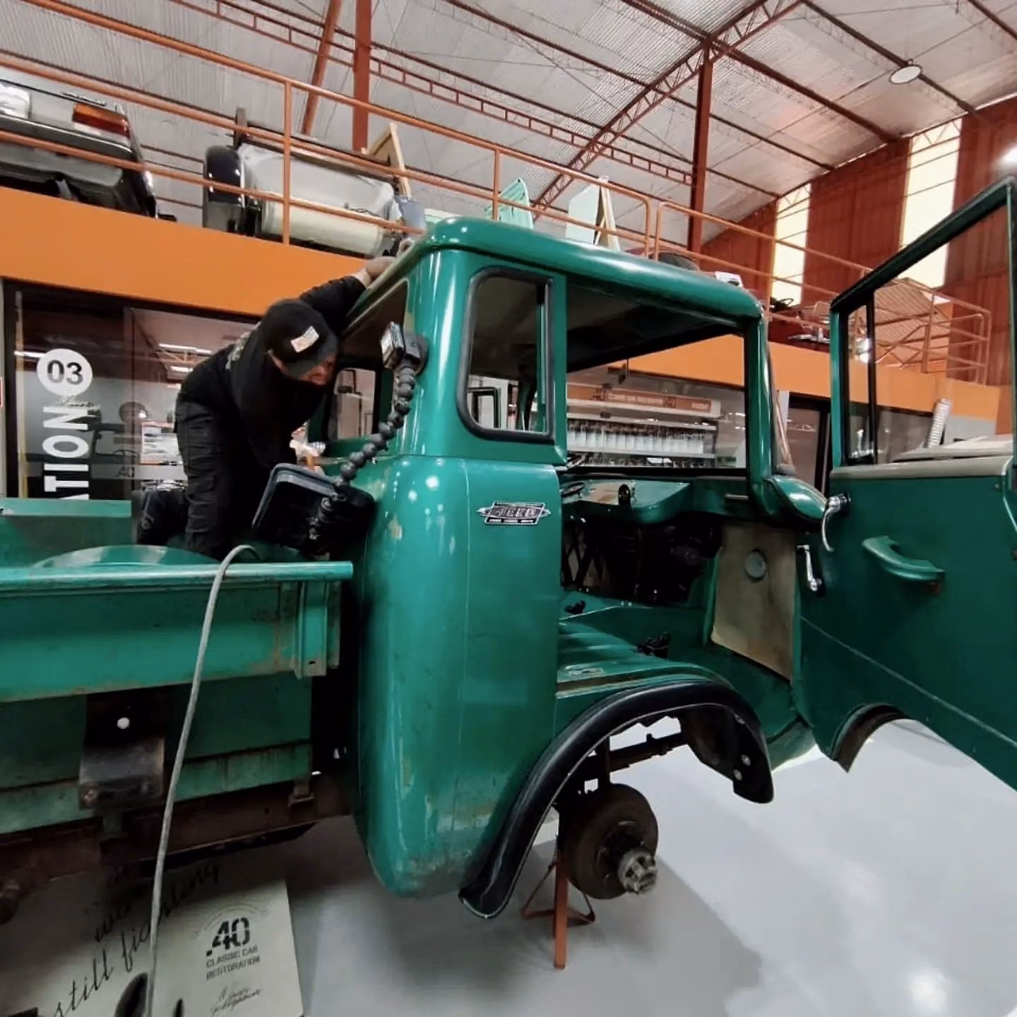 Caminhão antigo verde com a cabine em reparo